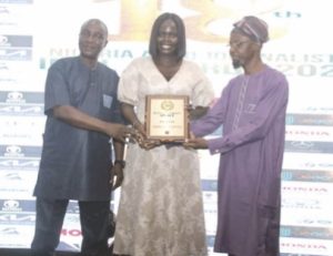Marketing Manager, Kia Nigeria, Omolade Akinyode (middle), receiving the Compact SUV award (won by Kia Seltos) at the 2025 NAJA Awards