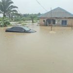 Submerged building and car by a destroyed fish farm
