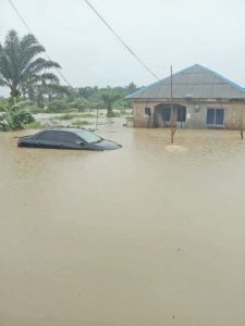Submerged building and car by a destroyed fish farm