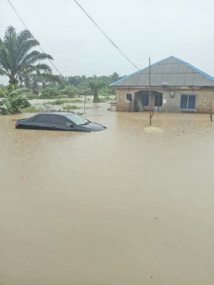 Submerged building and car by a destroyed fish farm