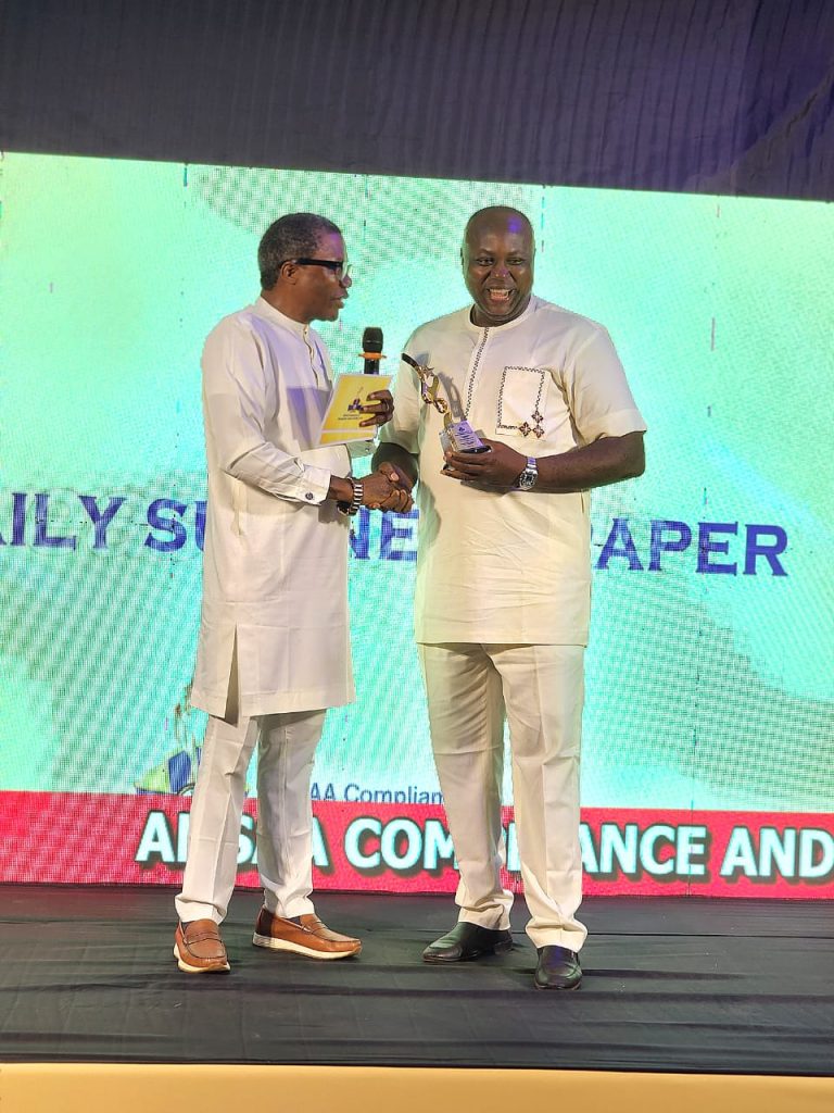 The Sun Correspondent, Aloysius Attah, receiving the Media Partner of the Year Award on behalf of The Sun MD, Mr Onuoha Ukeh, from Dr. Law Mefor, Anambra Commissioner for Information during the ANSAA Compliance and Recognition Award (ACRA) 2005 organised by the Anambra Signage and Advertising Agency (ANSAA) in Awka