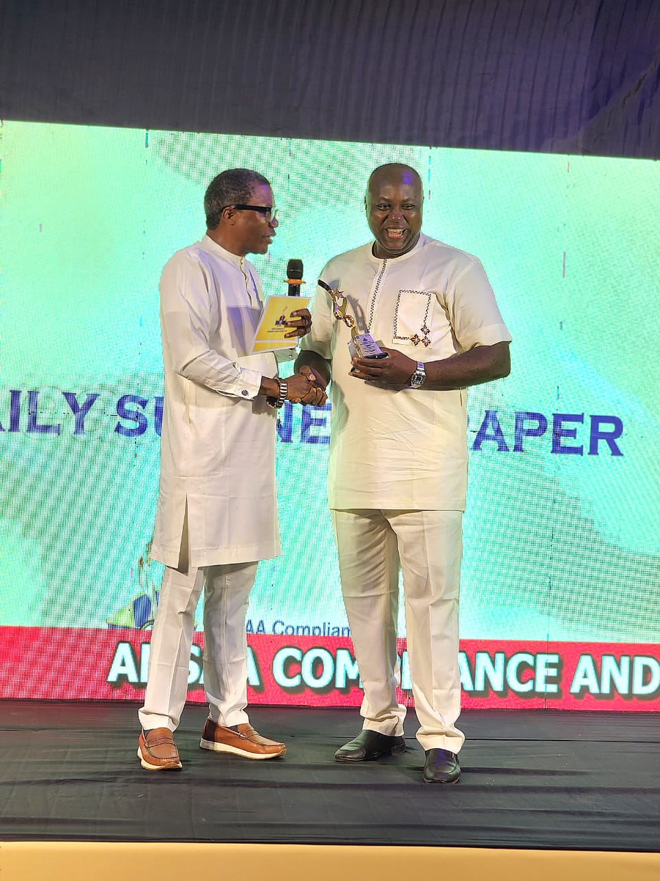 The Sun Correspondent, Aloysius Attah, receiving the Media Partner of the Year Award on behalf of The Sun MD, Mr Onuoha Ukeh, from Dr. Law Mefor, Anambra Commissioner for Information during the ANSAA Compliance and Recognition Award (ACRA) 2005 organised by the Anambra Signage and Advertising Agency (ANSAA) in Awka