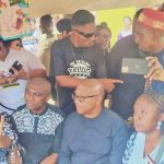 Obi (m) seated at the burial