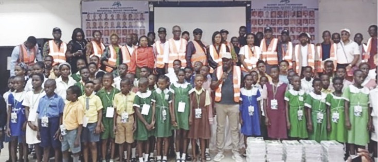 Akiba (middle) with students, parents and teachers of the selected schools