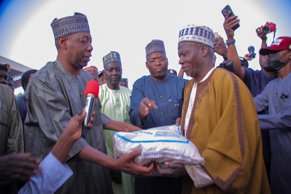 Borno governor, Babagana Zulum, handing over a bag of rice to a beneficiary during the flag off of the Food Distribution Exercise by the state government at Ramat Square, Maiduguri