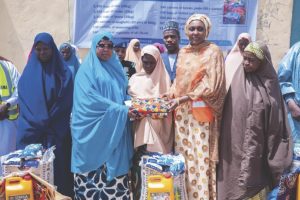 Hajia Idris and NEMA Director General, Hajia Zubaida Umar, distributing relief items to vulnerable people in Birnin Kebbi