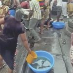 People scooping fuel from a fallen tanker