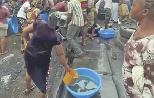 People scooping fuel from a fallen tanker