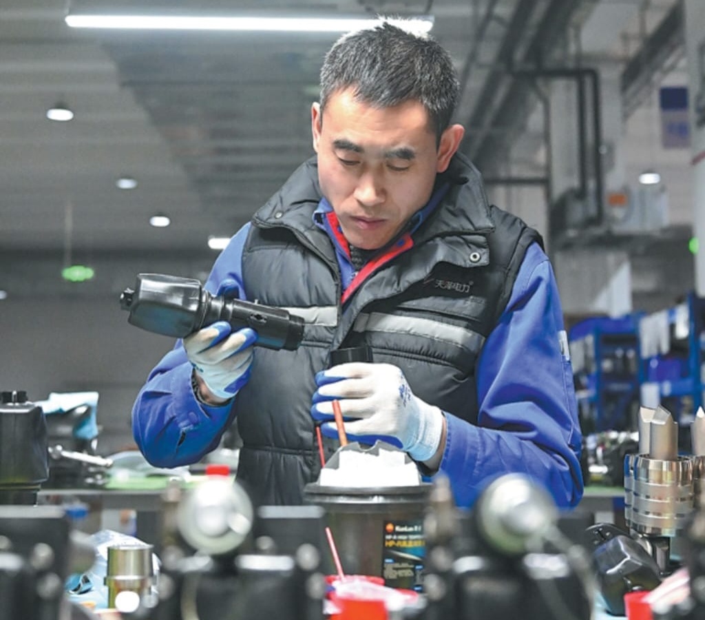 An employee assembles parts at an electric power company’s workshop in Beijing-Tianjin Zhongguancun tech town in Tianjin on Jan 30. SUN FANYUE/XINHUA.