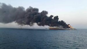 Fire billows from a struck Iranian warship off the coast of Oman