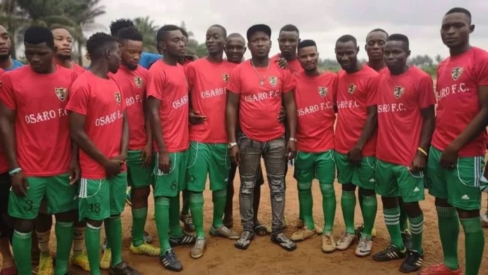 Lucky Osaro Godwin, founder of Osaro International Sports Academy, with some players from his academy.