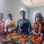 Some of the students of the centre receiving practical instruction in fabric measurement, pattern layout and material selection during a fashion design training session