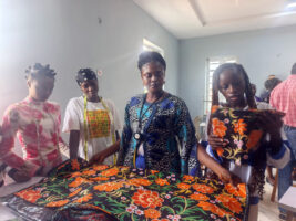 Some of the students of the centre receiving practical instruction in fabric measurement, pattern layout and material selection during a fashion design training session