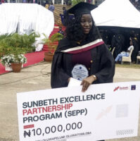 Amosu with the dummy cheque, plaque and certificate