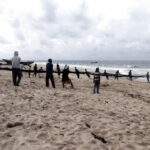 Team of fishmen pulling out the net from the sea
