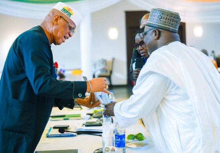 Governor Eno receiving award from Ndaji Alhassan, Registrar of NANNIM at Government House, Uyo