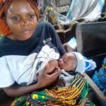 Mrs Iember Ati breastfeeding her baby in the market