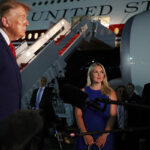 JOINT BASE ANDREWS, MARYLAND – AUGUST 11: White House Press Secretary Karoline Leavitt looks on as U.S. President Donald Trump speaks to reporters after stepping off Air Force One on August 11, 2026 in Joint Base Andrews, Maryland. Trump was asked about the secret decoy flight he took out of Turkey in a military aircraft. The president returning to Washington, DC after traveling to Ohio to attend the 2026 Patriot Games. (Photo by Anna Moneymaker/Getty Images)
