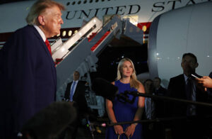 JOINT BASE ANDREWS, MARYLAND – AUGUST 11: White House Press Secretary Karoline Leavitt looks on as U.S. President Donald Trump speaks to reporters after stepping off Air Force One on August 11, 2026 in Joint Base Andrews, Maryland. Trump was asked about the secret decoy flight he took out of Turkey in a military aircraft. The president returning to Washington, DC after traveling to Ohio to attend the 2026 Patriot Games. (Photo by Anna Moneymaker/Getty Images)