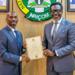 Mr. Olusegun Omosehin, Commission for nsurance (right), presenting the new operational licence to Mr. Babatunde Fajemirokun, the MD/CEO of AIICO Insurance Plc
