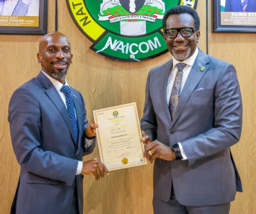Mr. Olusegun Omosehin, Commission for nsurance (right), presenting the new operational licence to Mr. Babatunde Fajemirokun, the MD/CEO of AIICO Insurance Plc