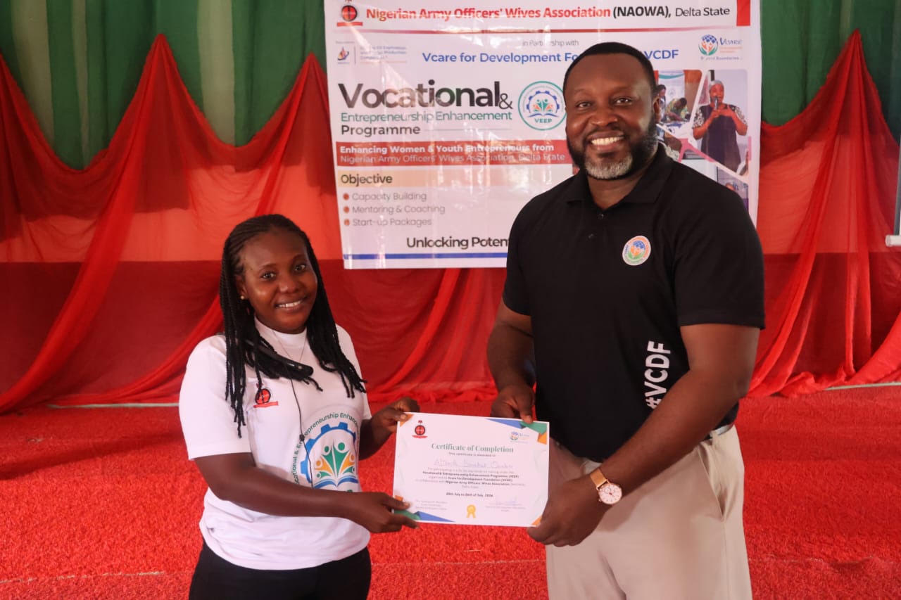The Deputy National Programmes Manager of VCDF, Mr Philip Ukemezia, presenting Certificate to a participant at Empowerment Training of Nigeria Officers Wives in Delta State
