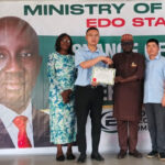 The Commissioner for Power, Hon. Paul Usenbo, presenting the Certificate to the management of the company
