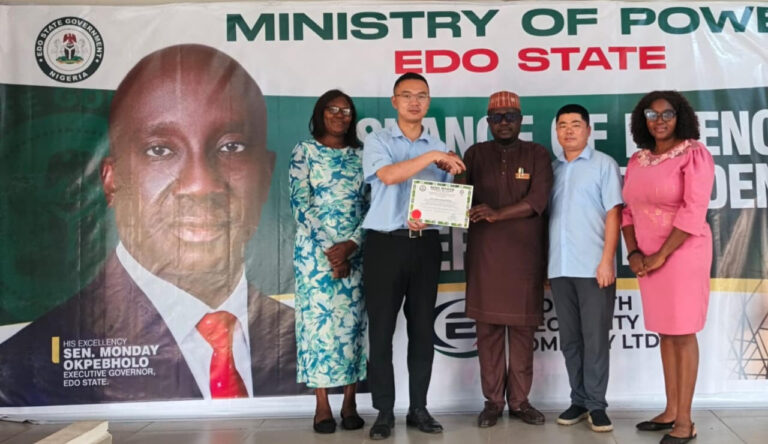The Commissioner for Power, Hon. Paul Usenbo, presenting the Certificate to the management of the company